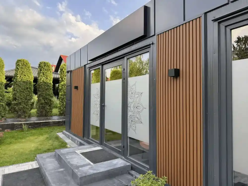 Nowoczesny pawilon modułowy z drewnianymi panelami elewacyjnymi i przeszklonym wejściem