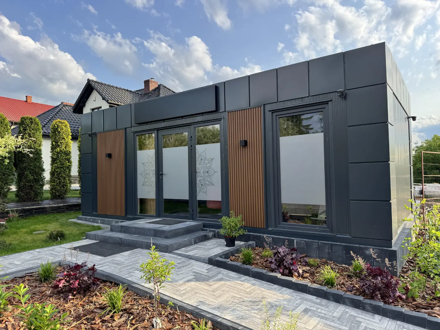 Nowoczesny pawilon modułowy z antracytową elewacją i przeszklonym wejściem